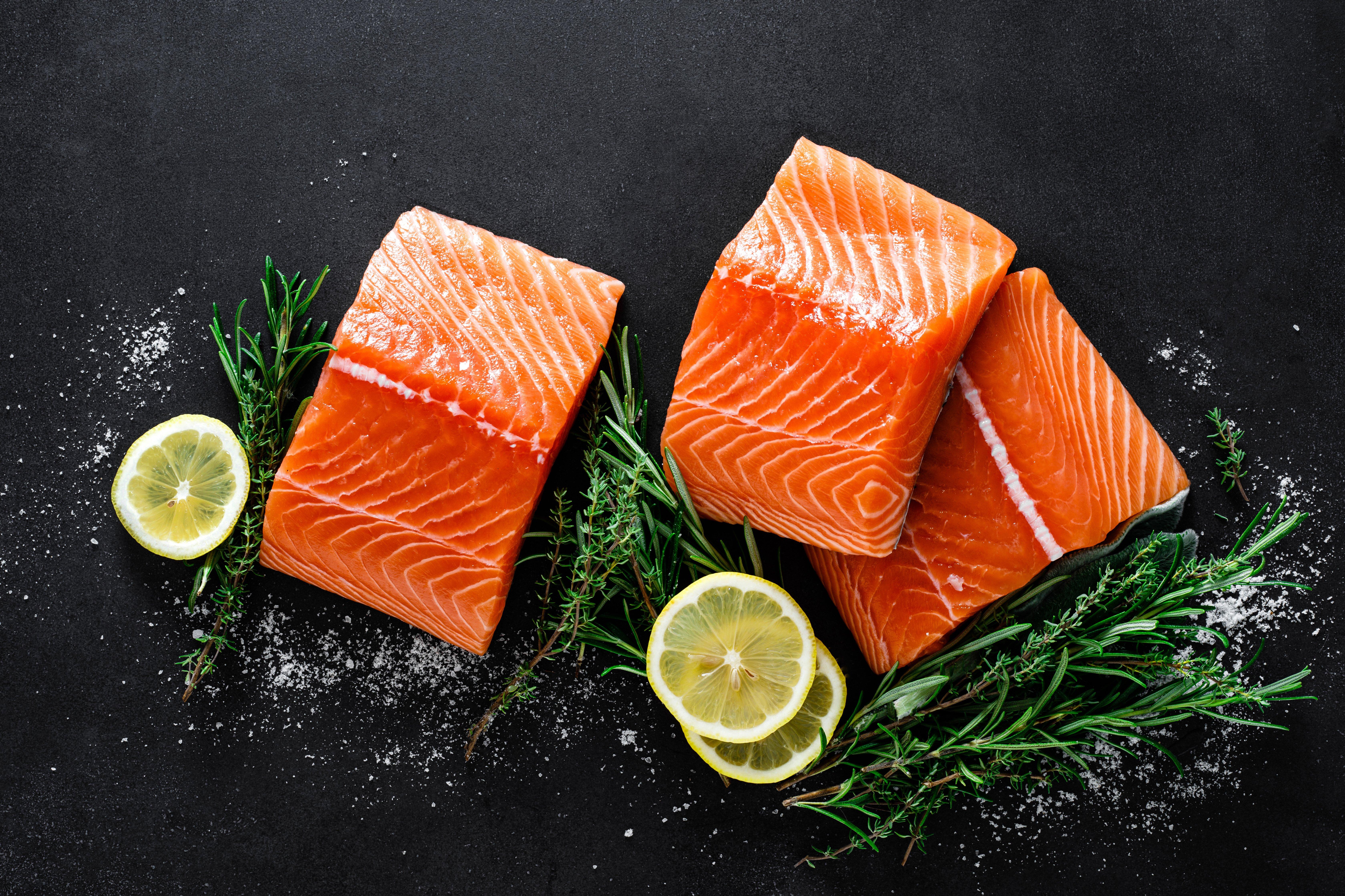 salmon-fresh-raw-salmon-fish-fillet-with-cooking-ingredients-herbs-and-lemon-on-black-background-1480384085